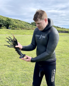 Jamie, holding a lobster he had caught spearfishing.